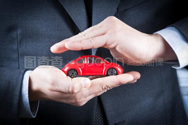 商人用手保护一辆红色汽车,用于保险、购买、租赁、燃料或服务的概念